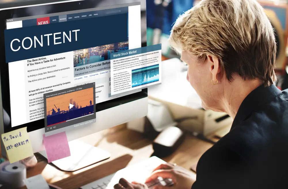 A lady typing a blog post on a computer screen. On the screen is boldly written "Content".